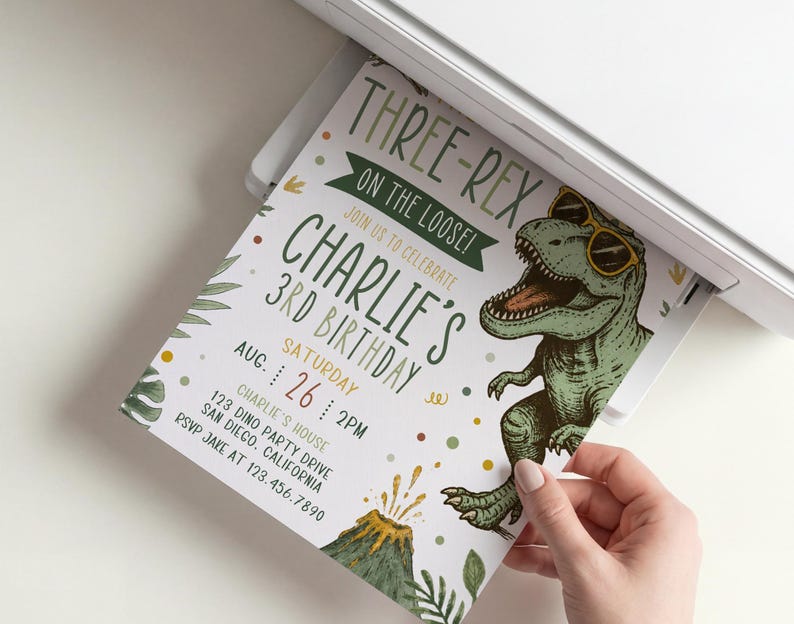 Pu&ograve; includere: Un biglietto d'invito di compleanno stampato con un T-Rex verde che indossa occhiali da sole gialli, un vulcano e foglie tropicali. Il testo recita: THREE-REX ON THE LOOSE! JOIN US TO CELEBRATE CHARLIE'S 3RD BIRTHDAY, SATURDAY AUG 26 2PM, CHARLIE'S HOUSE, 123 DINO PARTY DRIVE.