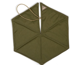 Può includere: Un tappetino esagonale in tessuto verde oliva con pannelli cuciti e un passante elastico color cuoio per la chiusura. Una piccola toppa triangolare color cuoio con il testo KAMA è cucita sul bordo superiore. L'articolo è in materiale tessile.