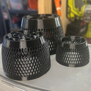 May include: Three black 3D printed mesh filters of different sizes. The filters are cylindrical and have a honeycomb pattern.