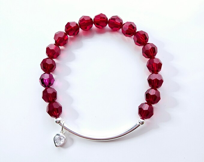 Austrian crystal bracelet with red crystal beads and silver diamond cut heart charm.