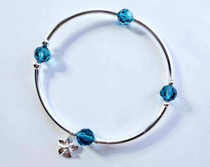 Truly Blessed, count your blessings bracelet with blue zircon birthstone and silver flower charm for December birthdays.