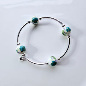 Truly Blessed, count those blessings bracelet with white porcelain beads with hand painted mint green floral design and silver charm.