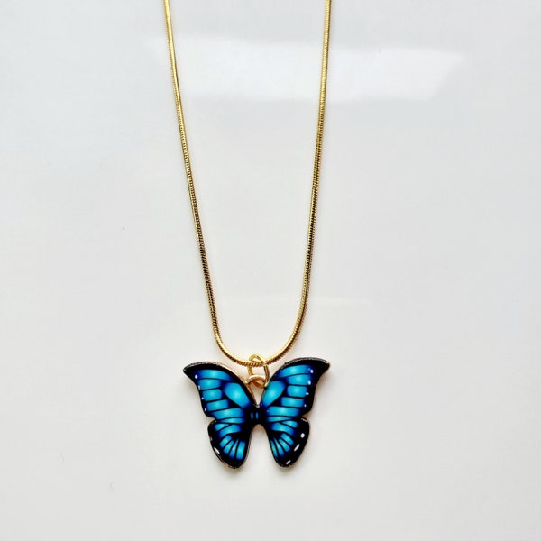 Electric blue butterfly necklace on gold snake chain
