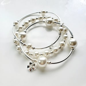 Truly Blessed-armbandtrio met Oostenrijkse kristalwitte parels en zilveren hart- en bloembedel.