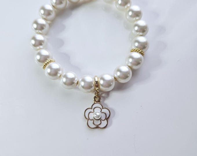 white Austrian crystal pearl charm bracelet with white enamel and gold plated flower charm.