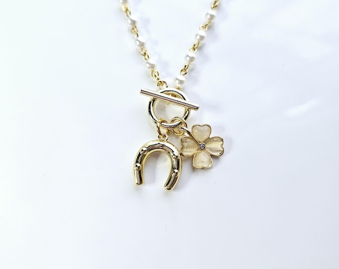Lucky horseshoe and 4 leaf clover charm necklace on gold rosary bead chain with toggle clasp.
