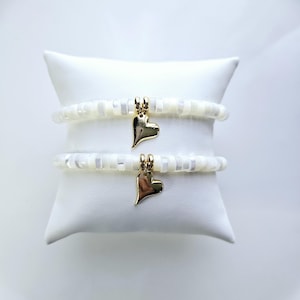 Bracelet mère fille avec perles Heishi en nacre blanche et breloque coeur en or 14 ct.