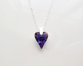 May include: A silver chain necklace with a purple heart-shaped pendant.
