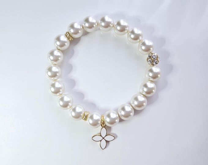 Austrian crystal pearlescent white pearl beads and white enamel and gold iconic flower charm.