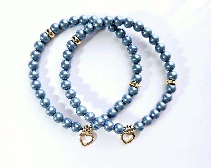 Connected by our hearts bracelets are made with Austrian crystal pearlescent blue pearls and 14kt gold filled heart charm.