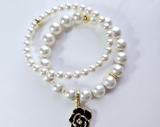 White Austrian crystal flower power pearl bracelet duo with black enamel and gold plated flower charm.