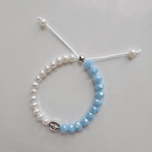 MIRACULOUS MARY bracelet with pearlescent white pearls and Virgin Mary charm.