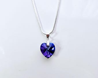 May include: A silver chain necklace with a purple heart-shaped pendant.