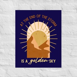 May include: A blue background with a golden sun and mountains. The text "At the end of the storm is a golden sky" is written in a white font.