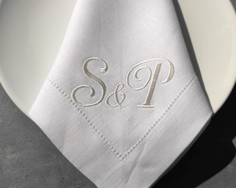 May include: White linen napkin with the initials "S & P" embroidered in silver thread.