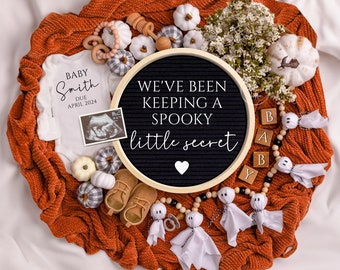 May include: A black letter board with the text "We've been keeping a spooky little secret" surrounded by white pumpkins, a white onesie with the text "Baby Smith Due April 2024", a white ultrasound image, and a wooden bead garland with ghost ornaments.