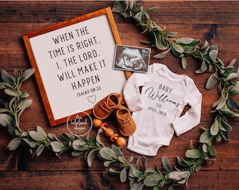 May include: A white onesie with the text "BABY Williams DUE APRIL 2024" on it, a framed sign with the text "WHEN THE TIME IS RIGHT. I. THE LORD. WILL MAKE IT HAPPEN ISAIAH 68:22", a pair of brown baby shoes, a wooden rattle, and a sonogram image on a wooden surface with greenery.