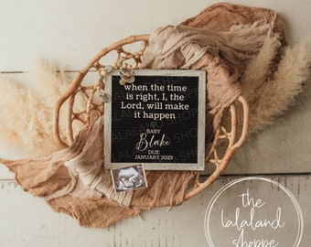May include: A black chalkboard sign with white text announcing the birth of a baby named Blake, due in January 2023. The sign is surrounded by a wicker basket and a tan fabric. The text on the sign reads "when the time is right, I, the Lord, will make it happen".