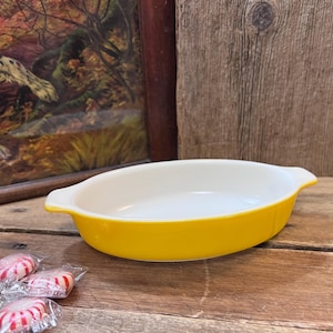 May include: A white ceramic mug with a black handle and the text "But First, Coffee" in a bold, black font. The mug is sitting on a wooden surface. The mug is approximately 4 inches tall.