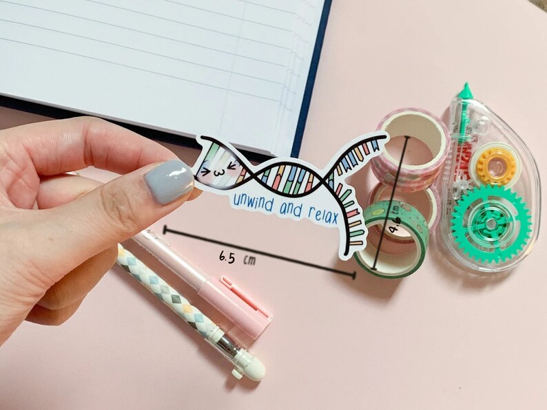 Op de afbeelding: Een kleurrijke DNA-streng sticker met de tekst "unwind and relax" en een schattig gezicht. De sticker is 6,5 cm lang.