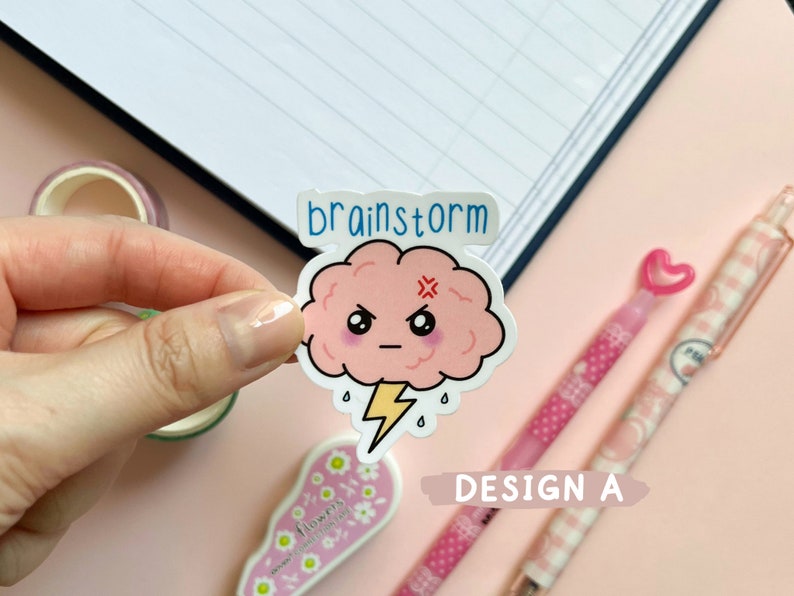 May include: A pink cartoon brain with a lightning bolt and the word "brainstorm" above it. The brain has a grumpy expression with a frown and an X for eyes. The sticker is on a pink background.