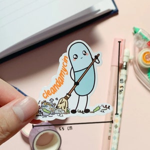 Puede incluir: Un personaje azul con forma de p&iacute;ldora con una cara amigable sostiene una escoba y barre un mont&oacute;n de bichos coloridos. El texto "cleandamycin" est&aacute; escrito en la escoba. La pegatina mide 5,5 cm de ancho.