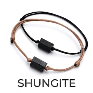 May include: Two adjustable bracelets featuring a single matte black hexagonal bead each. One bracelet has a tan cord, and the other has a black cord. The word SHUNGITE is printed in black capital letters below the two bracelets.
