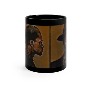Pu&ograve; includere: Tazza da caff&egrave; nera con una grafica di due volti maschili di profilo. Gli uomini si guardano e lo sfondo &egrave; di colore oro spento.