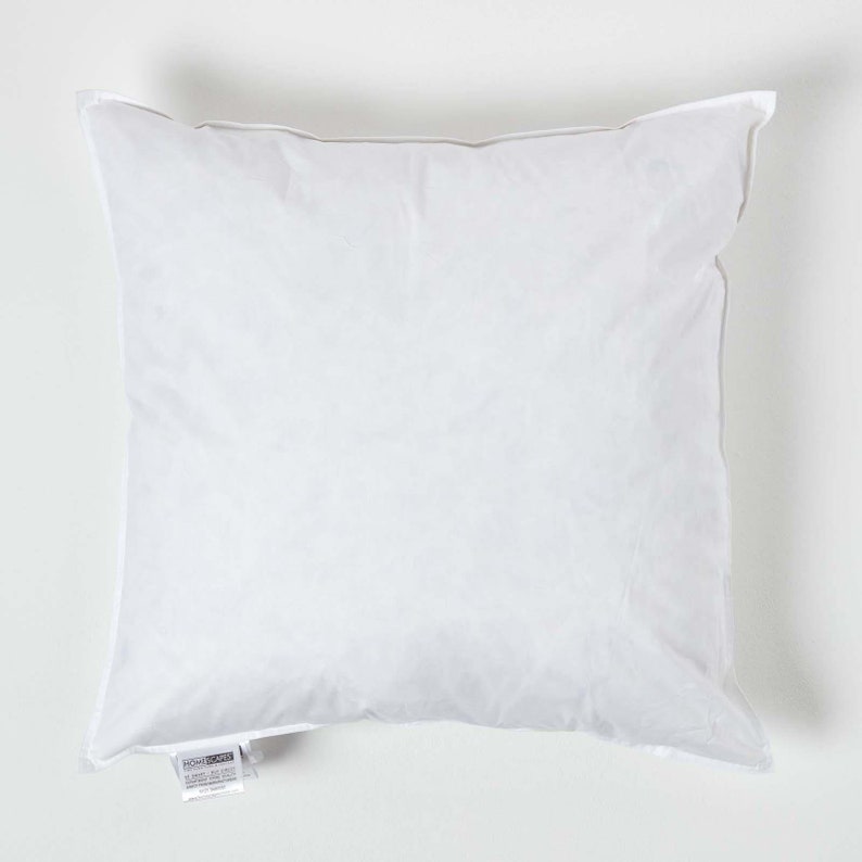 May include: A white pillow with a white fabric cover. The pillow is rectangular and has a label on the bottom corner that says "HOMECRAFT".