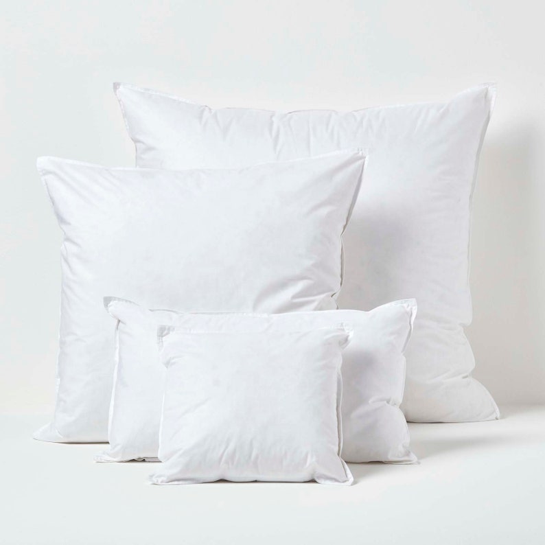 May include: Four white pillowcases of different sizes, arranged in a pyramid shape on a white background.