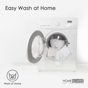 May include: A white washing machine with the door open, revealing white laundry inside. The machine has a digital display and a control panel. The text "Easy Wash at Home" is displayed above the machine. A washing instruction icon with a 40 degree symbol is displayed below the machine. The text "Wash at Home" is displayed below the icon. The text "HOME SCAPES SLEEP LIVING BED & BATH" is displayed below the machine.