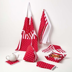 May include: A set of red and white polka dot kitchen accessories, including an apron, oven mitts, and a bread basket. The accessories are made of cotton and have a white and red polka dot pattern.