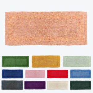 May include: A collection of bath mats in various colours, including green, yellow, light green, blue, pink, red, dark blue, grey, purple, beige, and dark green. The mats are made of a soft, fluffy material and have a rectangular shape.