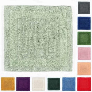 May include: A light green bath mat with a fluffy texture. The mat is shown against a white background. The mat is available in a variety of colours, including grey, blue, green, pink, peach, yellow, purple, cream, and red.