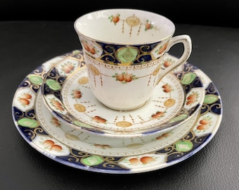 May include: A vintage teacup and saucer set with a floral pattern in shades of blue, green, and gold. The set features a delicate floral design with a gold trim.