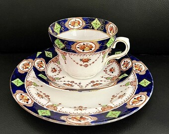 May include: A vintage teacup and saucer set with a blue and white floral pattern. The cup and saucer have a gold trim and a delicate floral design.
