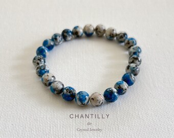 May include: A blue and white speckled stone beaded bracelet. The bracelet is made of natural stones and is a beautiful and unique piece of jewelry.