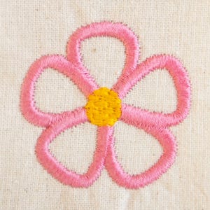 May include: A close-up of an embroidered flower with five pink petals and a yellow center. The flower is stitched on a cream-colored fabric, showcasing the texture of the embroidery and the fabric.