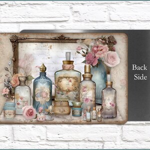 K&ouml;nnte beinhalten: Eine vintage-inspirierte Sammlung von Glasflaschen mit verzierten Etiketten und Stopfen, angeordnet auf einem Regal mit einem gerahmten St&uuml;ck Papier dahinter. Die Flaschen sind mit verschiedenen Fl&uuml;ssigkeiten gef&uuml;llt und einige haben Blumen und andere dekorative Elemente. Die Flaschen sind von rosa Rosen und anderen floralen Akzenten umgeben.