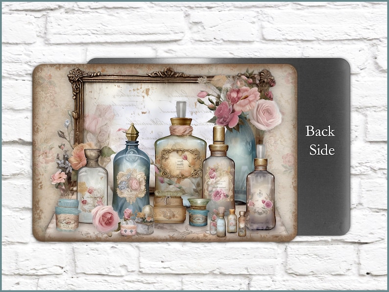 K&ouml;nnte beinhalten: Eine vintage-inspirierte Sammlung von Glasflaschen mit verzierten Etiketten und Stopfen, angeordnet auf einem Regal mit einem gerahmten St&uuml;ck Papier dahinter. Die Flaschen sind mit verschiedenen Fl&uuml;ssigkeiten gef&uuml;llt und einige haben Blumen und andere dekorative Elemente. Die Flaschen sind von rosa Rosen und anderen floralen Akzenten umgeben.
