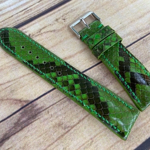 May include: Green snakeskin watch strap with white stitching. The strap is made of genuine leather and has a classic design.