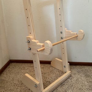 Puede incluir: Un telar de madera natural. El marco rectangular tiene clavijas para los hilos de urdimbre. Cuenta con componentes ajustables y una varilla de madera para tejer. Diseñado para crear textiles tejidos, sus dimensiones son en centímetros.