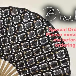 May include: A black hand fan with a repeating hexagonal lace pattern and light-colored wooden ribs. The image includes the text Black- and Special Order. Please message me before ordering.