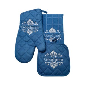 May include: A blue quilted oven mitt, a blue quilted pot holder, and a blue and white checkered kitchen towel. All three items are embroidered with the word "Goodman" in white.