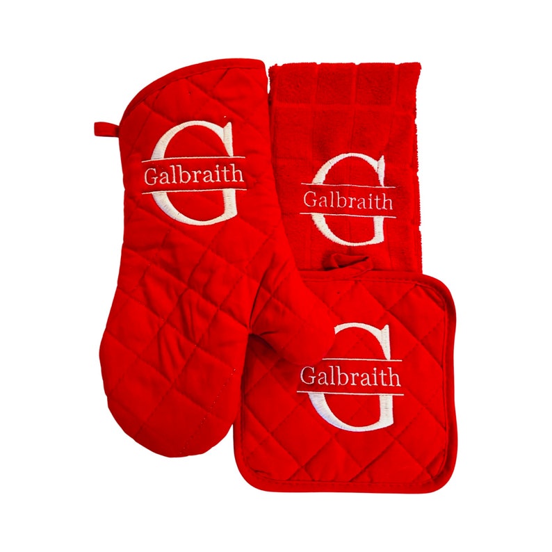 May include: Red quilted kitchen set with a potholder, oven mitt, and tea towel. Each item features a white embroidered letter "G" with the name "Galbraith" underneath.