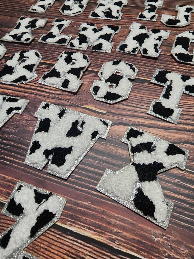 Peut inclure: Un ensemble de lettres thermocollantes &agrave; imprim&eacute; vache noir et blanc. Les lettres sont en gras, en caract&egrave;res gras et sont parfaites pour ajouter une touche de personnalit&eacute; aux v&ecirc;tements, aux sacs ou &agrave; d'autres articles en tissu.