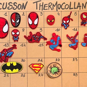 Peut inclure: Une collection d'écussons thermocollants brodés disposés sur une grille intitulée ECUSSON THERMOCOLLANT. Les écussons représentent diverses poses de Spider-Man, un logo Batman, un emblème Superman et un poing de Hulk en rouge, bleu et jaune.