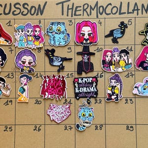 Peut inclure: Une collection d'écusson thermocollants avec divers motifs, dont des personnages de style anime, un chat, un corbeau et du texte. Les écussons présentent des couleurs vives et des illustrations détaillées, pour décorer des vêtements ou accessoires.