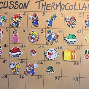 Puede incluir: Una colección de parches bordados termoadhesivos con varios personajes e iconos de Super Mario, incluyendo a Mario, Luigi, la Princesa Peach, Toad, Yoshi, un fantasma Boo, un bloque de interrogación y caparazones, dispuestos en una cuadrícula ECUSSON THERMOCOLLANT.