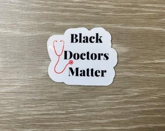 Può includere: Etichetta bianca con un fonendoscopio rosso e testo nero che dice "Black Doctors Matter".
